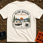 Sip Slow Roll Easy - T-Shirt in Ivory - A graphic illustration of a white camper van driving on a winding road toward a...