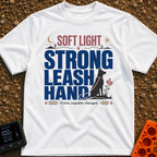 Leash The Day - T-Shirt in White - A typographic design featuring the text "SOFT LIGHT STRONG LEASH HAND" alongside the...
