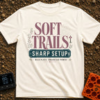 Wired For The Wild - T-Shirt in Ivory - A typographic design featuring the words "SOFT TRAILS" in large serif letters...