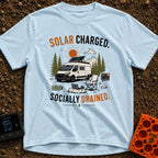 Solar Charged Socially Done - T-Shirt in Chambray - A white camper van with a tilted roof solar panel is parked near pine...