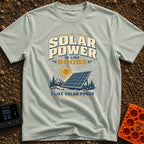 Solar Is Like Boobs - T-Shirt in Bay - A large, freestanding solar panel sits on the ground in a natural landscape...