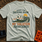 Pardon My Pace - T-Shirt in Bay - A white Class C motorhome drives along a two-lane highway toward mountains and a...