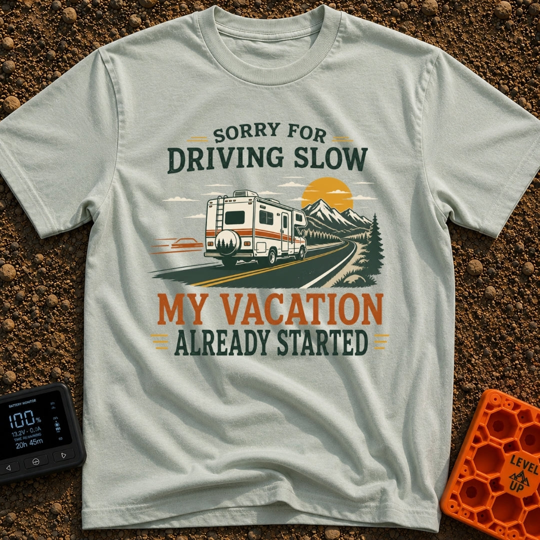 Pardon My Pace - T-Shirt in Bay - A white Class C motorhome drives along a two-lane highway toward mountains and a...