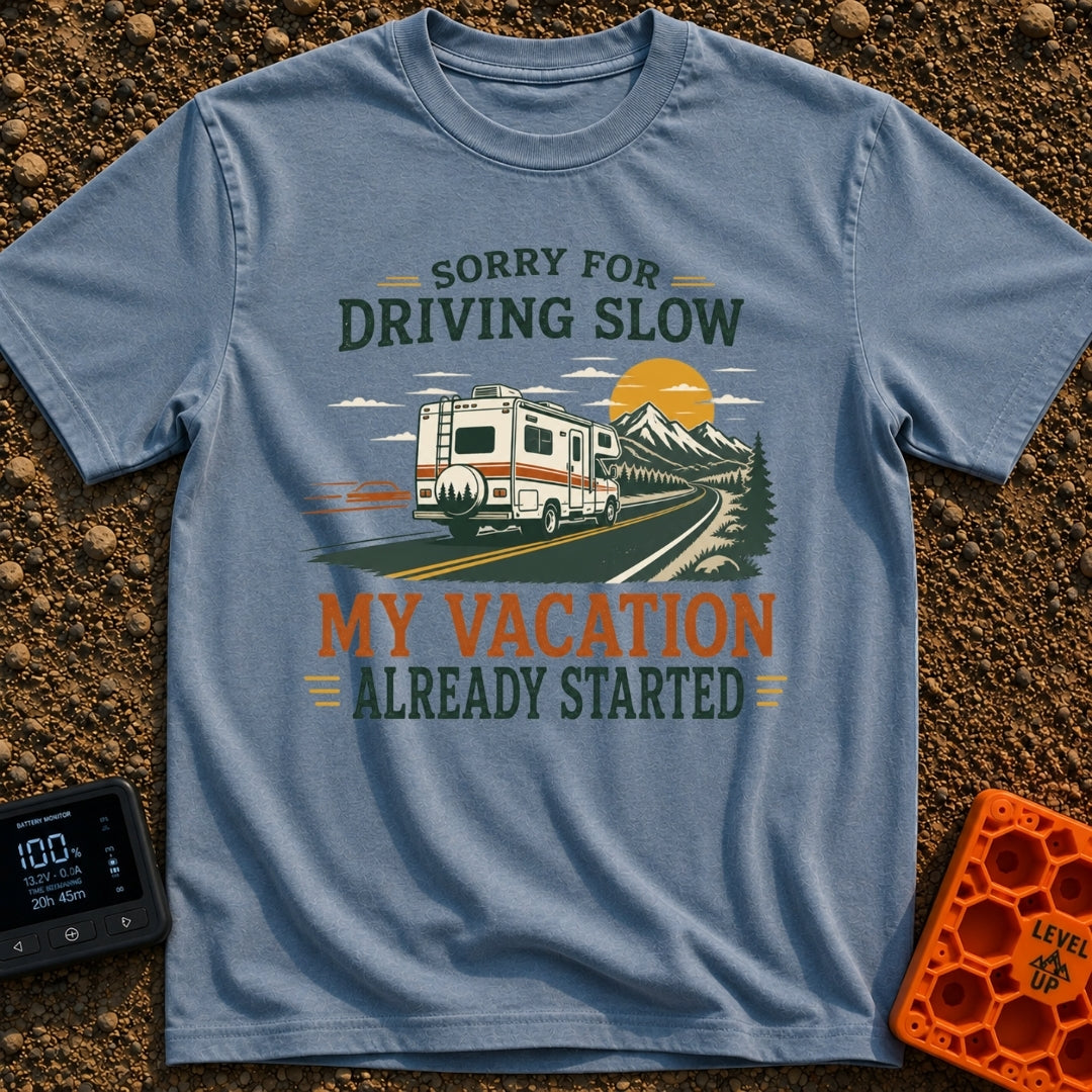 Pardon My Pace - T-Shirt in Blue Jean - A white Class C motorhome drives along a two-lane highway toward mountains and a...