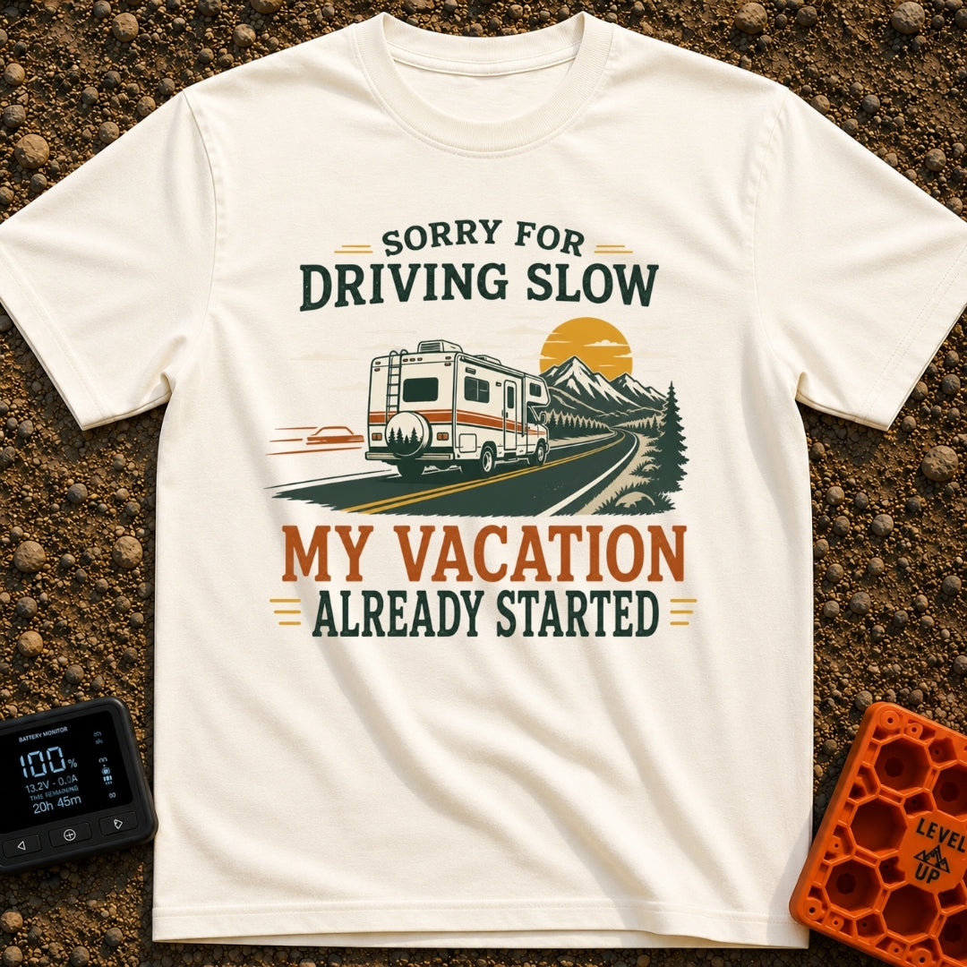 Pardon My Pace - T-Shirt in Ivory - A white Class C motorhome drives along a two-lane highway toward mountains and a...