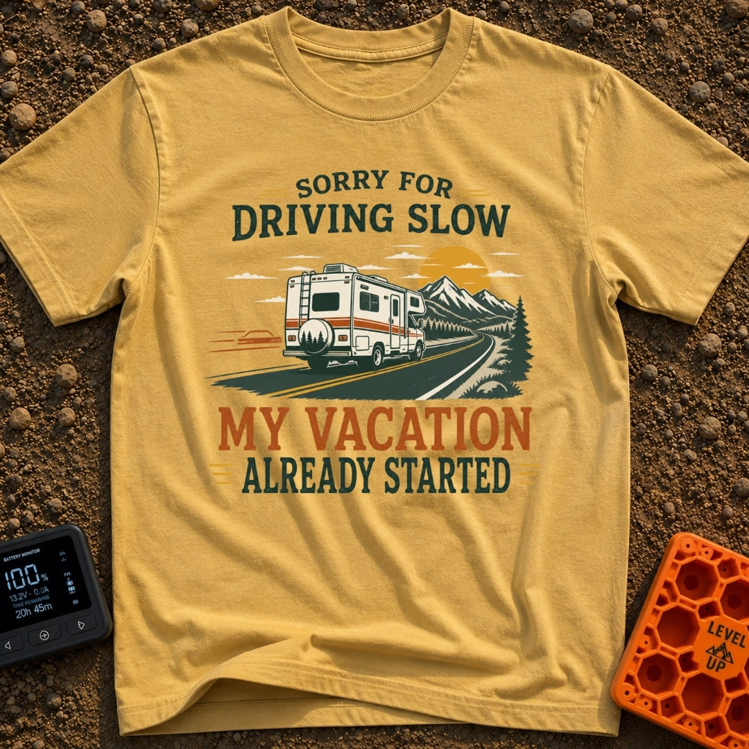Pardon My Pace - T-Shirt in Mustard - A white Class C motorhome drives along a two-lane highway toward mountains and a...