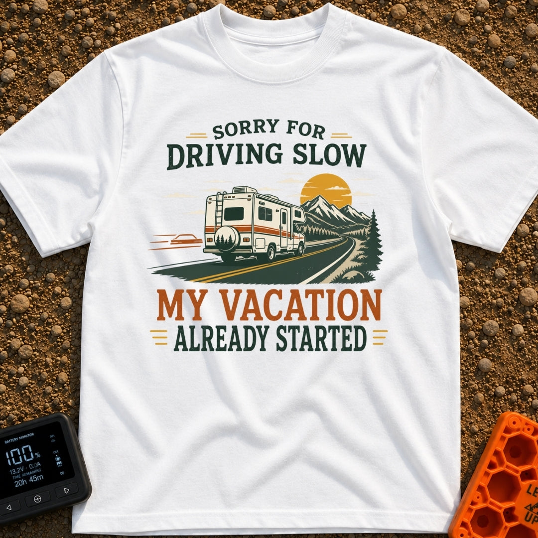 Pardon My Pace - T-Shirt in White - A white Class C motorhome drives along a two-lane highway toward mountains and a...