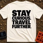 Driven By Curiosity - T-Shirt in Ivory - A text-only design featuring the phrase "STAY CURIOUS. TRAVEL FURTHER." stacked...