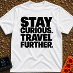 Driven By Curiosity - T-Shirt in White - A text-only design featuring the phrase "STAY CURIOUS. TRAVEL FURTHER." stacked...