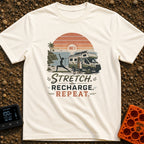Stretch And Recharge - T-Shirt in Ivory - A silhouette of a woman doing a yoga pose on a mat beside an RV camper parked...