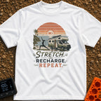 Stretch And Recharge - T-Shirt in White - A silhouette of a woman doing a yoga pose on a mat beside an RV camper parked...