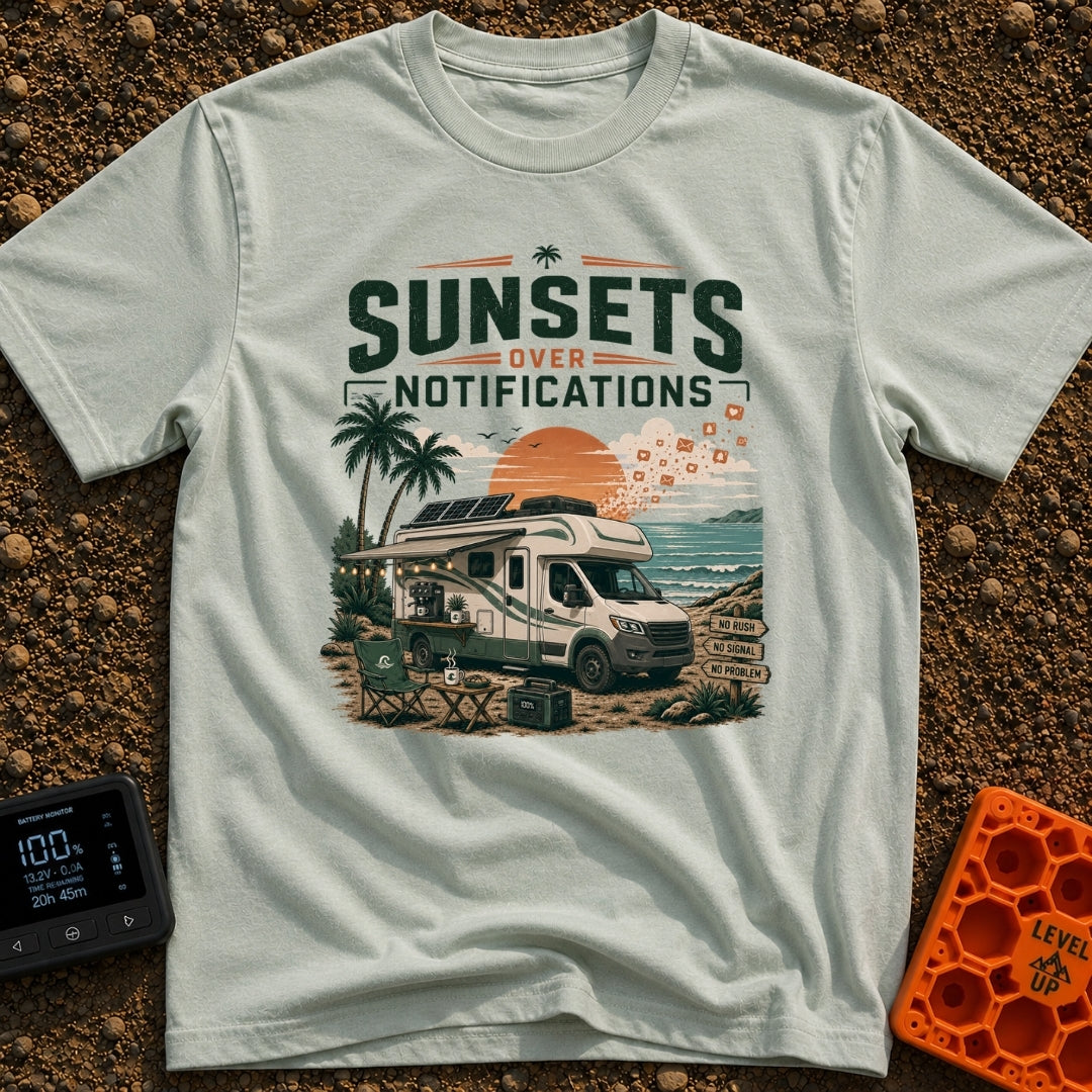 Sunsets Over Screens - T-Shirt in Bay - An RV parked on a beach at sunset with solar panels on the roof, an awning...