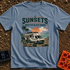 Sunsets Over Screens - T-Shirt in Blue Jean - An RV parked on a beach at sunset with solar panels on the roof, an awning...