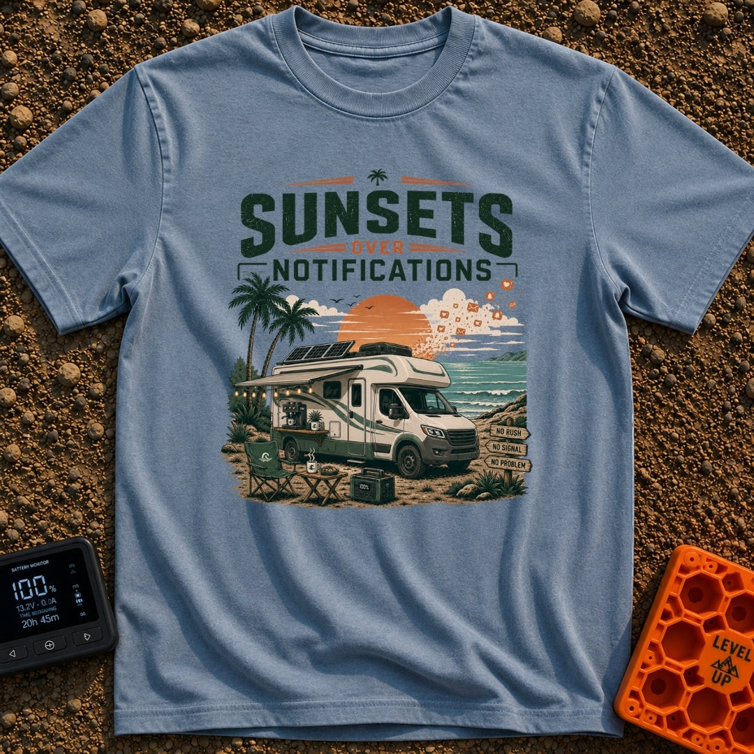 Sunsets Over Screens - T-Shirt in Blue Jean - An RV parked on a beach at sunset with solar panels on the roof, an awning...