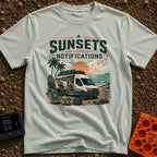 Sunsets Over Screens - T-Shirt in Bay - A camper van is parked on a beach at sunset with its side door open, revealing a...