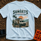 Sunsets Over Screens - T-Shirt in Chambray - A camper van is parked on a beach at sunset with its side door open,...
