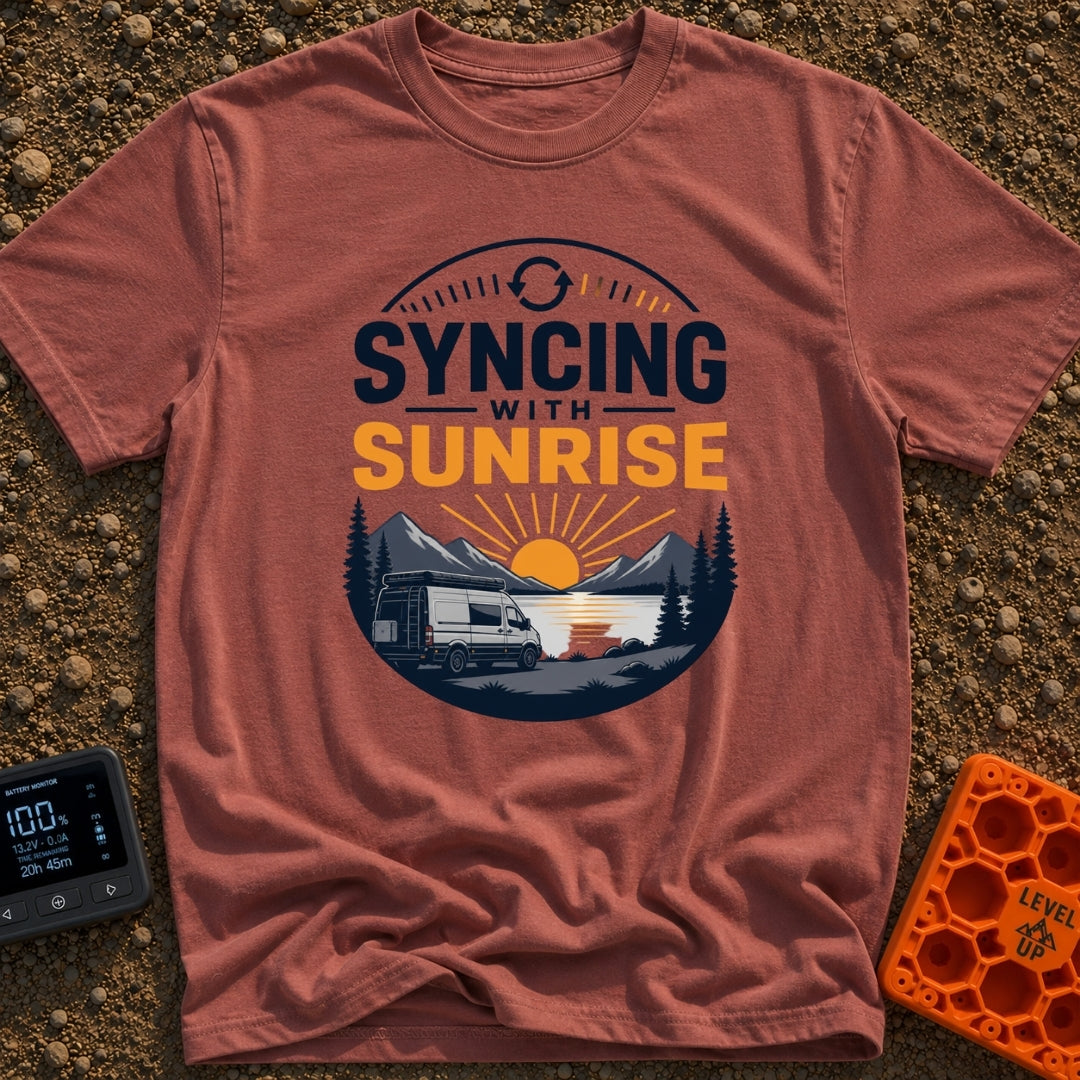 Rise And Sync - T-Shirt in Brick - A circular badge design featuring a white camper van parked by a lake with mountains...