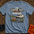 The Coffee Never Lies - T-Shirt in Blue Jean - An illustration of a camper van parked on leveling blocks in a mountain...