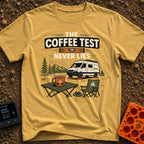 The Coffee Never Lies - T-Shirt in Mustard - An illustration of a camper van parked on leveling blocks in a mountain...