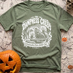The Damp Creeps In - T-Shirt in Moss - A black-and-white illustration of a swamp creature with webbed hands pressing...
