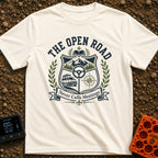 Roads Over Meetings - T-Shirt in Ivory - A heraldic crest design featuring a mountain range with pine trees, a steering...