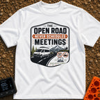 Roadtrips Not Meetings - T-Shirt in White - A crest-style design featuring a white camper van driving on a mountain road...