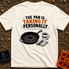 Skillet's Grudge Match - T-Shirt in Ivory - An illustration of a cast iron skillet holding a severely burnt pancake,...