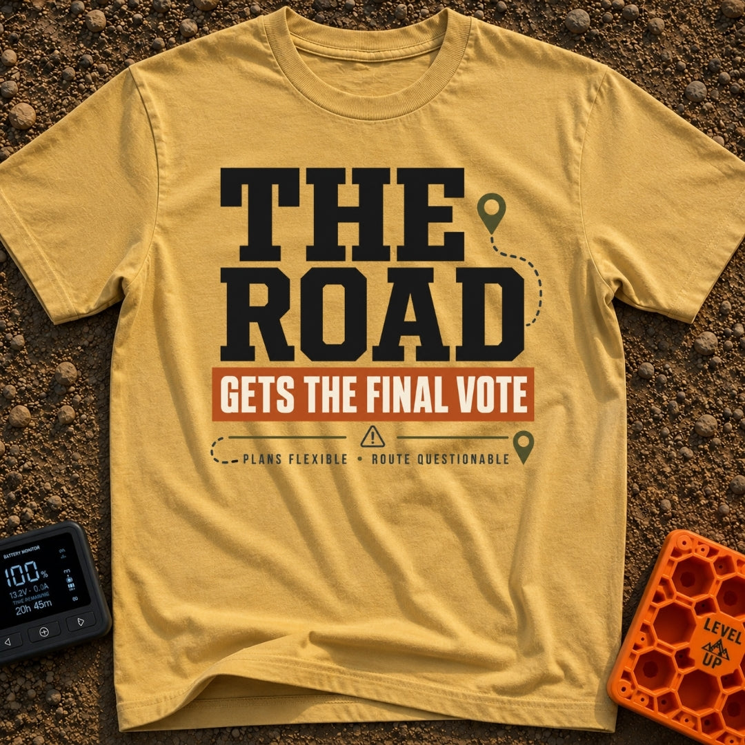 The Road Votes Last - T-Shirt in Mustard - A typographic design featuring the large text "THE ROAD" above a brown banner...