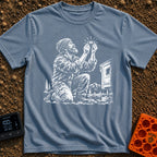 In Bubble We Trust - T-Shirt in Blue Jean - A white line-art illustration showing a bearded man kneeling beside a camper...
