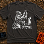 In Bubble We Trust - T-Shirt in Graphite - A white line-art illustration showing a bearded man kneeling beside a camper...
