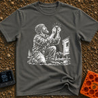 In Bubble We Trust - T-Shirt in Pepper - A white line-art illustration showing a bearded man kneeling beside a camper...