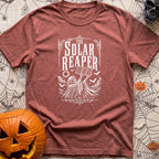 Reap What You Sun - T-Shirt in Brick - A black-and-white, vintage-style illustration of the Grim Reaper holding a folding...