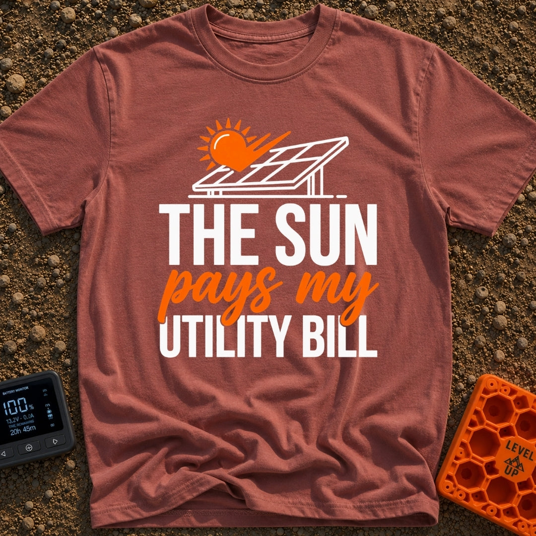 Sun Pays My Bills - T-Shirt in Brick - A graphic featuring a stylized orange sun shining on a tilted solar panel. Below...
