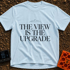 Upgrade To The View - T-Shirt in Chambray - A minimalist, text-focused design featuring the stacked phrase "THE VIEW IS...