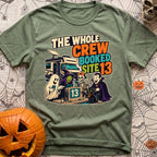 The Whole Crew Booked - T-Shirt in Moss - A cartoon illustration featuring the text 'THE WHOLE CREW BOOKED SITE 13' above...