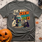 The Whole Crew Booked - T-Shirt in Pepper - A cartoon illustration featuring the text 'THE WHOLE CREW BOOKED SITE 13'...