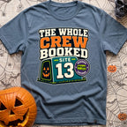 The Whole Crew Booked - T-Shirt in Blue Jean - A typographic design reading 'THE WHOLE CREW BOOKED', above a teal...