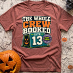 The Whole Crew Booked - T-Shirt in Brick - A typographic design reading 'THE WHOLE CREW BOOKED', above a teal campsite...