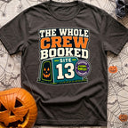 The Whole Crew Booked - T-Shirt in Graphite - A typographic design reading 'THE WHOLE CREW BOOKED', above a teal campsite...