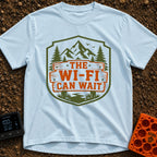 Mountains Over Modems - T-Shirt in Chambray - A badge-shaped graphic featuring green mountains, pine trees, and a winding...