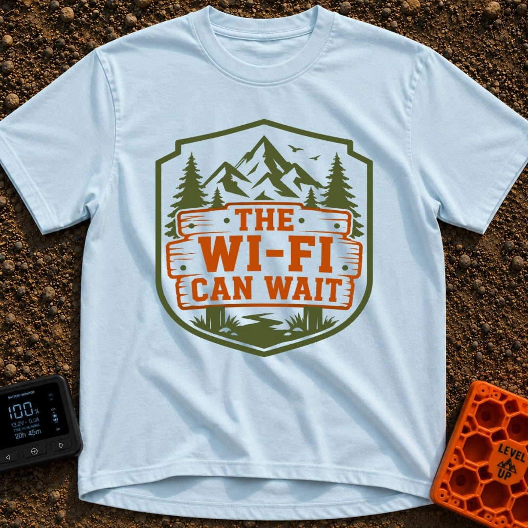 Mountains Over Modems - T-Shirt in Chambray - A badge-shaped graphic featuring green mountains, pine trees, and a winding...