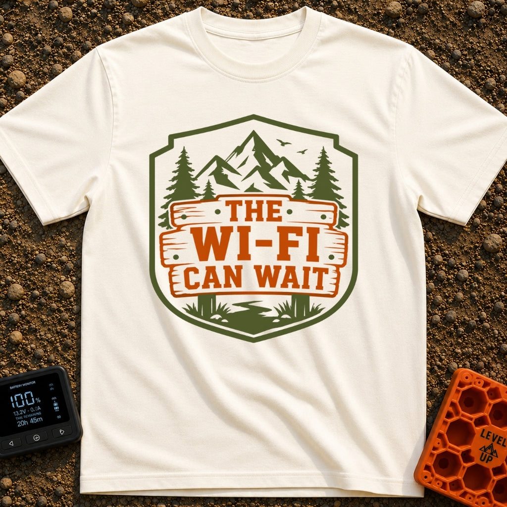 Mountains Over Modems - T-Shirt in Ivory - A badge-shaped graphic featuring green mountains, pine trees, and a winding...
