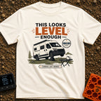 Leaning Tower Camper - T-Shirt in Ivory - A cartoon illustration of a white camper van parked on uneven terrain with its...
