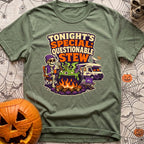 Tonights Questionable Stew - T-Shirt in Moss - A cartoon skeleton wearing a beanie and vest sits in a camp chair holding...