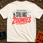 Still Has Zoomies - T-Shirt in Ivory - A typography-based design reading "TRAIL DOG STATUS: STILL HAS ZOOMIES" with...