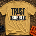 Trust The Bubble - T-Shirt in Mustard - A typographic design featuring the words "TRUST THE BUBBLE" alongside...