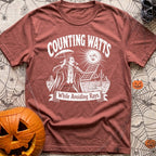 The Vampires Dilemma - T-Shirt in Brick - A line drawing of a vampire standing in a desert landscape, holding a parasol...