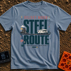 Velvet Ride Steel Route - T-Shirt in Blue Jean - A graphic design featuring an RV driving on a road through a desert...