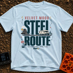 Velvet Ride Steel Route - T-Shirt in Chambray - A graphic design featuring an RV driving on a road through a desert...