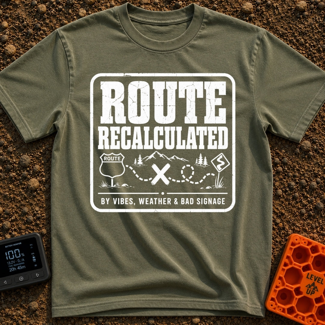 Navigating By Vibes - T-Shirt in Moss - A black and white distressed badge design featuring the text "ROUTE RECALCULATED"...
